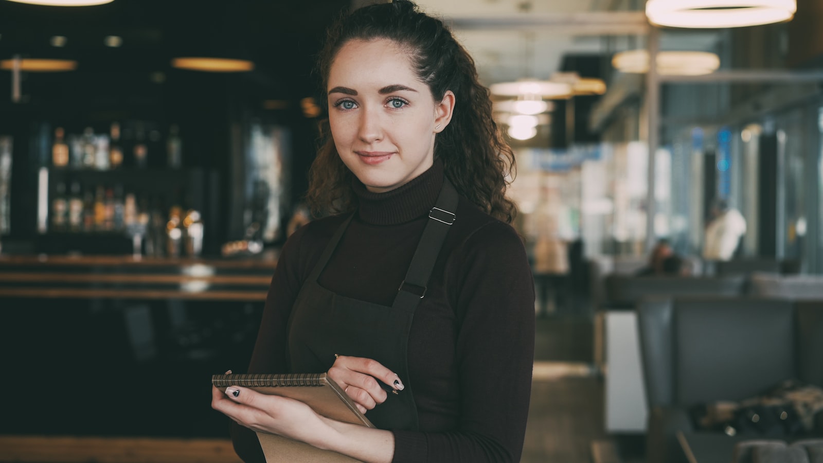 Restaurant staff clocking in with a phone and tablet in store